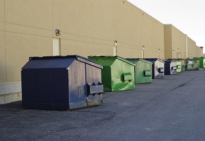 a row of blue construction dumpsters on a job site in Frankton